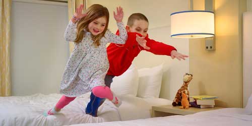 Happy Kids Jumping on Bed - Greater Merrimack Valley MA